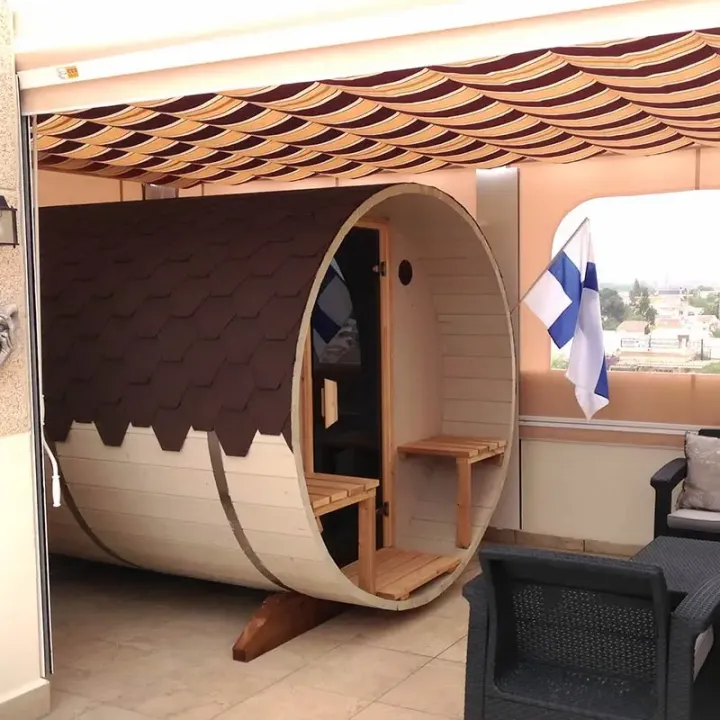 tynnyrisauna sähkökiukaalla talon terassilla