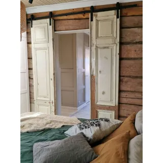 Kaksi vintage‑ovea asennettuna LADON liukuovikiskoon sisätilassa