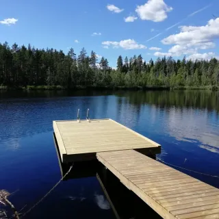 Putkiponttonilaituri mökkijärvellä – suora kelluva laituri ja kävelysilta 6×3,15 m, ruskea kestopuu.