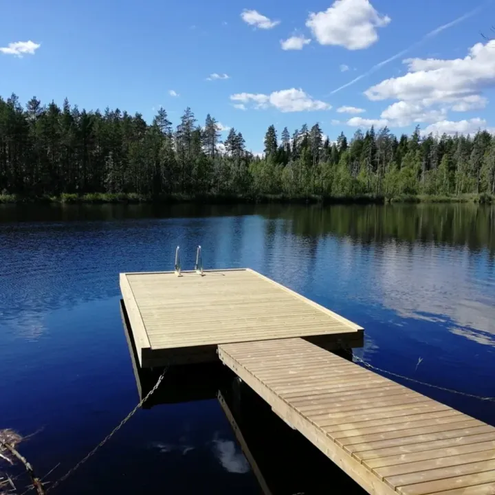 Putkiponttonilaituri mökkijärvellä – suora kelluva laituri ja kävelysilta 6×3,15 m, ruskea kestopuu.